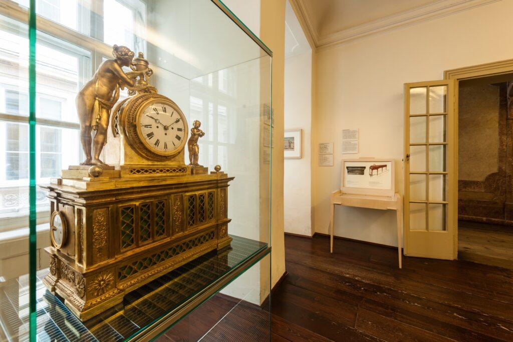 Historische goldene Uhr hinter Glas in einem Museum.
